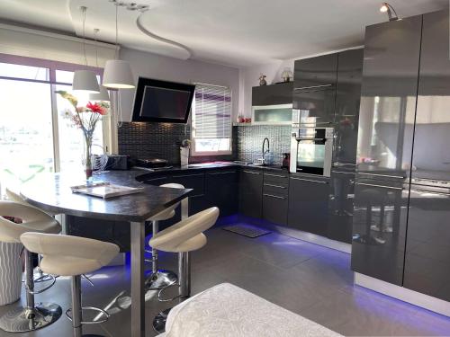 une cuisine avec une table avec des chaises et un réfrigérateur dans l'établissement Confortable appt 2 pièces avec grande terrasse, clim, garage, proche mer et commerces - FR-1-226A-165, à Fréjus