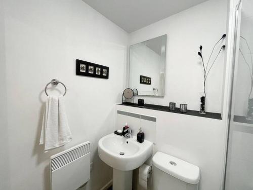 La salle de bains blanche est pourvue d'un lavabo et de toilettes. dans l'établissement Cityfront Modern Apt Near City Centre/Etihad, Free Parking, à Manchester