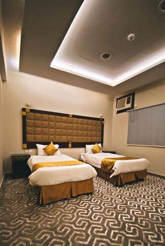 a hotel room with two beds and a projection screen at فندق اضواء المدينة in Sīdī Ḩamzah