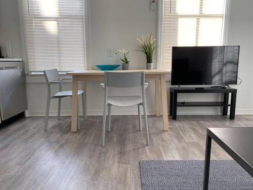 a kitchen with a table with chairs and a television at Chic Bungalow Apartment steps from Armature Works & Downtown Riverwalk in Tampa