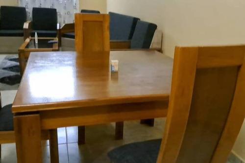 drewniany stół i krzesła w pokoju w obiekcie Villa 2 chambres-Salon w mieście Wagadugu