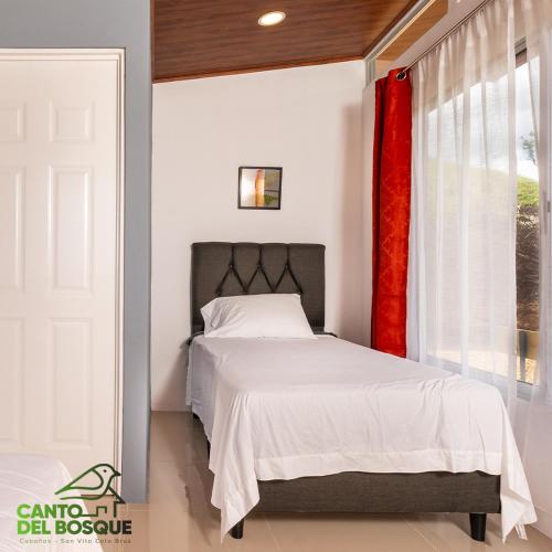 a bedroom with a white bed and a window at Canto Del Bosque in San Vito