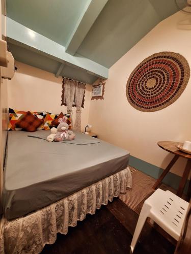 um quarto com uma cama com um urso de peluche em Balai Vivencio Hostel em Puerto Princesa