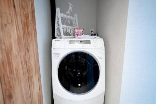 a white washing machine in a corner of a room at NEWOPEN Villa lanikai in Kabira