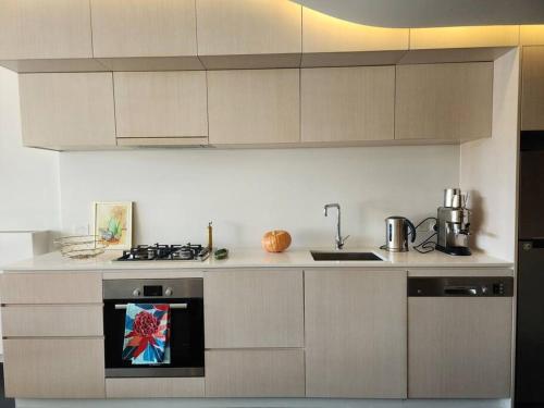 a kitchen with white cabinets and a stove top oven at GREEN ROSE Quiet Spacious Lakeside Carpark Exceptional 70m2 in Canberra