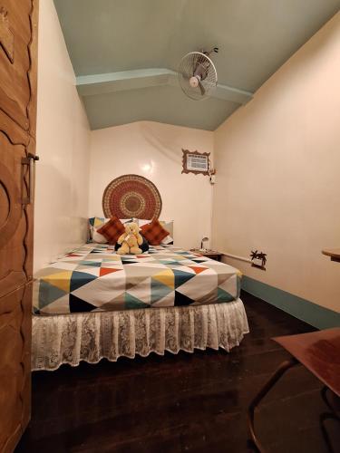 Un dormitorio con una cama con un osito de peluche. en Balai Vivencio Hostel en Puerto Princesa