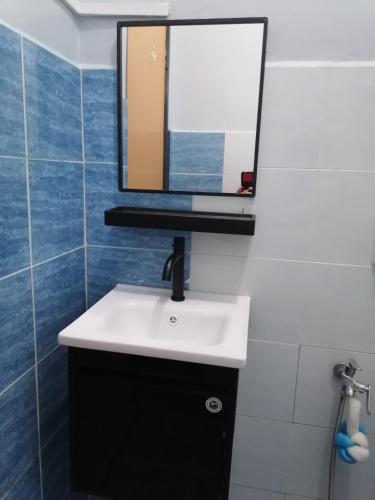 a bathroom with a sink and a mirror on the wall at DKAMAR Homestay At Desaru, Fully Aircond, WiFi, Coway, Street View 4 min to Desaru Beach in Kangkar Chemaran