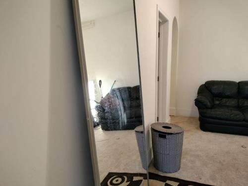 a mirror in front of a living room with a couch at Gorgeous ,stylish and Beautiful Luxury Apartment with stuning Downtown View.Featuring American and French style in Frederick