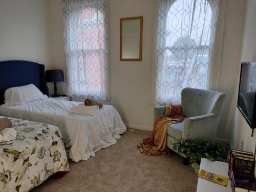 a bedroom with a bed and a chair and windows at Gorgeous ,stylish and Beautiful Luxury Apartment with stuning Downtown View.Featuring American and French style in Frederick