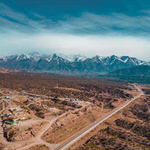 an aerial view of a desert with a road and mountains at Reflejo del Lago - Cabañas frente al Dique Potrerillos in Ciudad Lujan de Cuyo