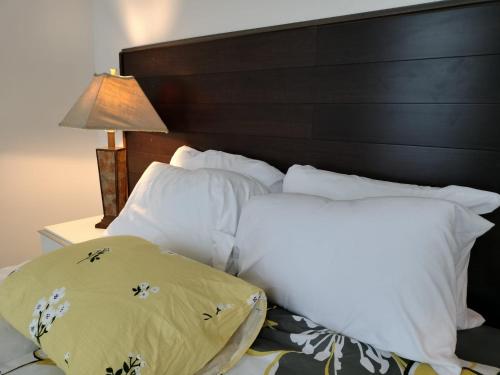 a bed with white pillows and a wooden headboard at Gorgeous ,stylish and Beautiful Luxury Apartment with stuning Downtown View.Featuring American and French style in Frederick