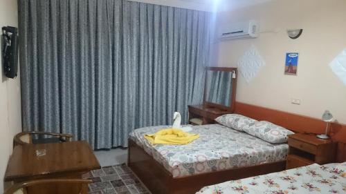 a bedroom with two beds and a yellow robe on the bed at Hotel Grün in Kızılot