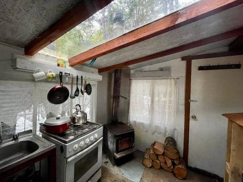 a kitchen with a stove and a stove top oven at Refugio El Cauque in Puerto Williams