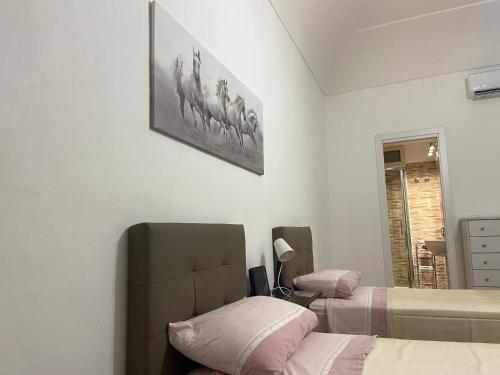 um quarto com duas camas e uma foto na parede em Casa vacanza La Collegiata em Catânia