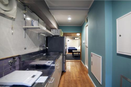 a kitchen with a sink and a refrigerator at KANDA HOUSE!! Shin-Okubo Walkable Modern Stay with Shinjuku Access in Tokyo