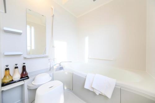 La salle de bains blanche est pourvue d'un lavabo et de toilettes. dans l'établissement Fuji Onsenji Yumedono, à Fujikawaguchiko