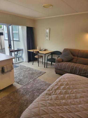 a living room with a couch and a table at Totara Lodge Motel in Levin