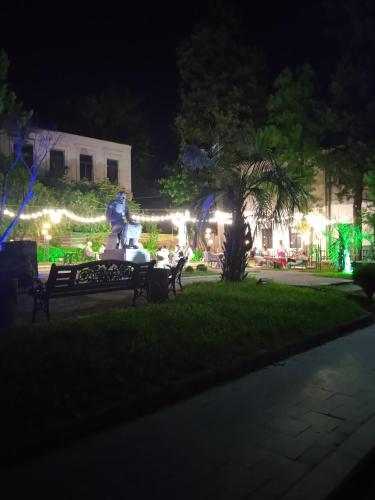 a park at night with a statue and lights at House 1891 in Kutaisi