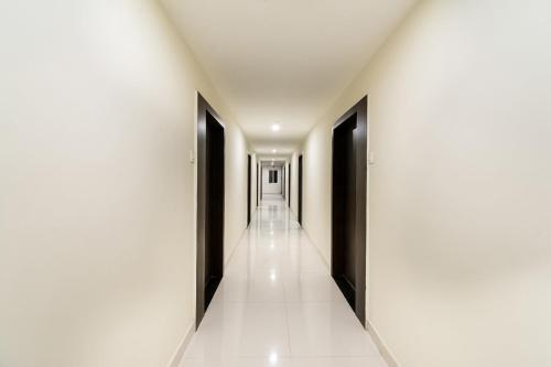 un corridoio con porte nere e pavimenti piastrellati bianchi di Hotel CJ Inn a Gunadala