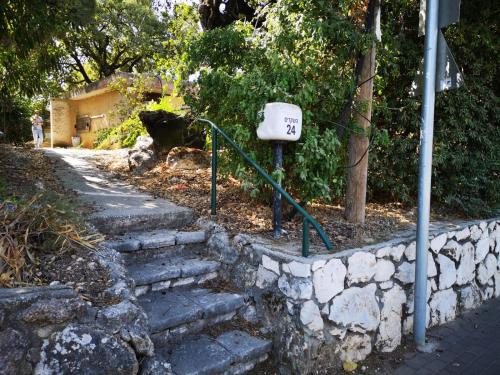 a set of stairs next to a stone wall at בית בטבעון in Ramat Hadassa