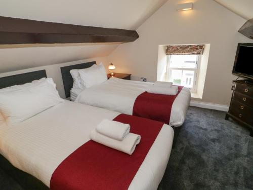 スランディドノにあるTrevor Cottageのベッド2台とテレビが備わるホテルルームです。