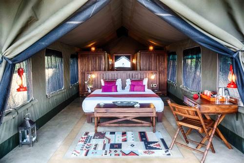 a bedroom in a tent with a bed and a desk at Madulkelle Tea and Eco Lodge in Kandy