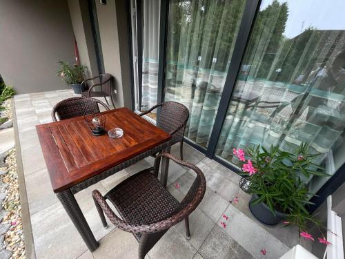 a wooden table and chairs sitting on a patio at Elina Apartman in Keszthely