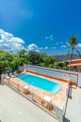 a swimming pool with lounge chairs around it at Pousada Vista do Rio in Barreirinhas