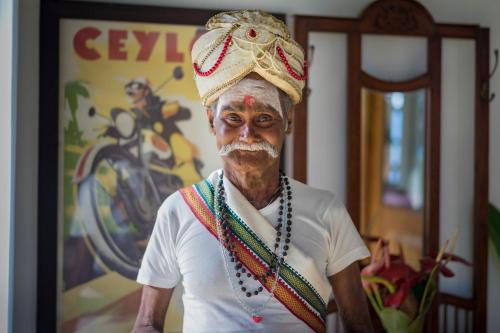 an older man wearing a hat and a beard at Madulkelle Tea and Eco Lodge in Kandy