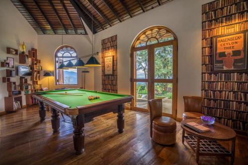 a billiard room with a pool table and a library at Madulkelle Tea and Eco Lodge in Kandy