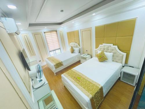 a hotel room with two beds and a television at Bài Thơ Mountain Hotel in Ha Long
