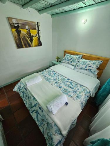 ein kleines Bett in einem Zimmer mit einem Bild an der Wand in der Unterkunft PUEBLITO BOYACENSE - Hospedaje El Cocuy in Duitama