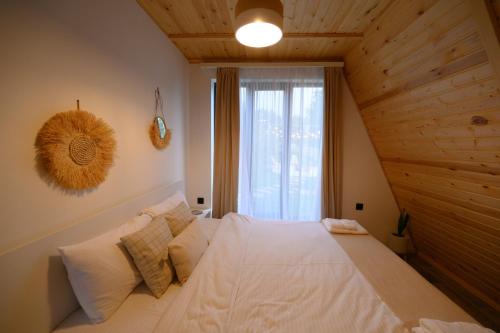 una camera da letto con un grande letto bianco di fronte a una finestra di Lake House A Frame a Gyulagarak