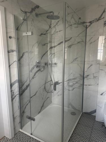 a shower with a glass door in a bathroom at Apartmány Harmony Liptov in Liptovský Mikuláš