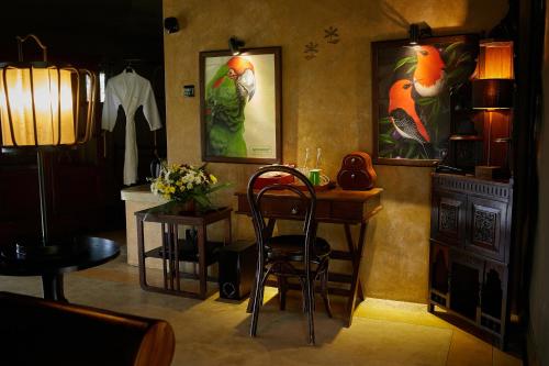 a room with a desk with a chair and paintings on the wall at Madulkelle Tea and Eco Lodge in Kandy