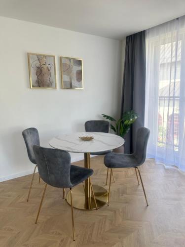 a dining room with a table and four chairs at Apartmány Harmony Liptov in Liptovský Mikuláš