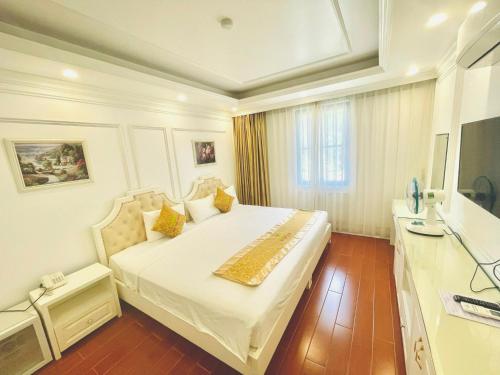 - une chambre avec un grand lit et une télévision dans l'établissement Bài Thơ Mountain Hotel, à Hạ Long