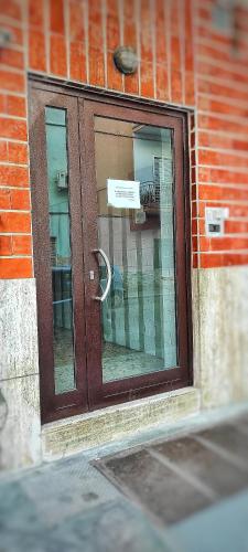 a glass door on a brick building with a sign on it at CasApulia - Bari Airport apartment in Bitonto