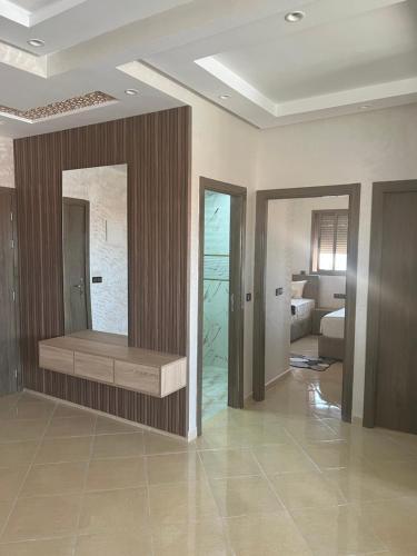 a room with a bathroom with a tub and a bedroom at L'horizon Aéroport Appartement in Marrakech