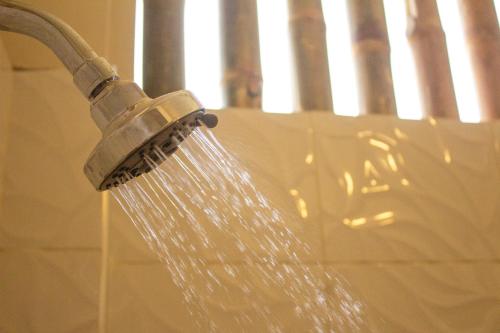 un cabezal de ducha con agua saliendo de él en Panorama garden inn, en Máncora