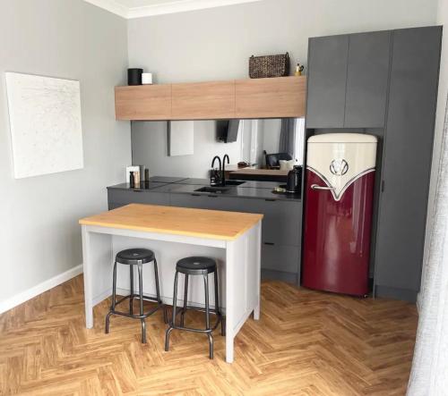 uma cozinha com uma mesa, 2 bancos e um frigorífico em Cute annexe - close to Manly Marina em Brisbane