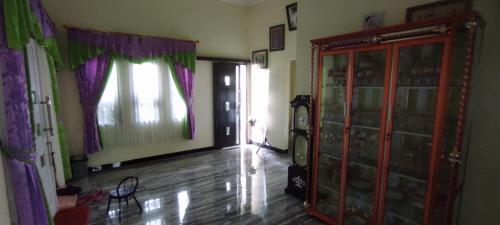 een woonkamer met een raam en een houten vloer bij Alesya Homestay 