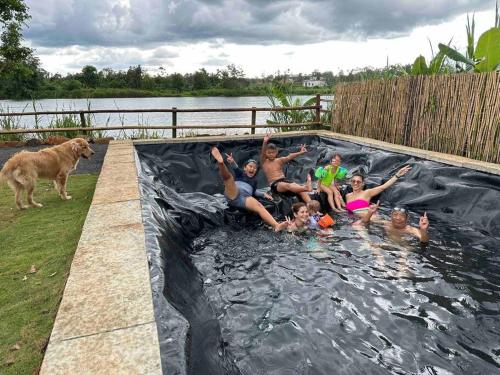 un groupe de personnes assises dans une piscine dans l'établissement Tam An Lakeview House, à Buôn Ma Thuột