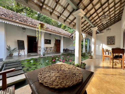 a living room with a patio with a pond with flowers at Foozoo Mantra Weligama in Weligama