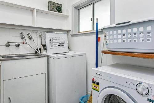 a kitchen with a washing machine and a sink at Garden Cottage in Leura