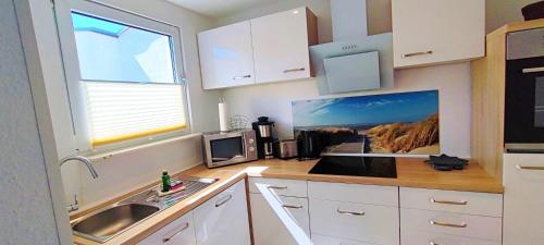 una cocina con fregadero y una foto de la playa en Ferienhaus Pearl en Ueckeritz