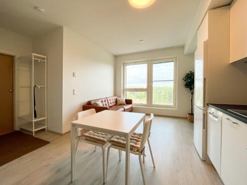 uma cozinha e sala de estar com mesa e cadeiras em New studio apartment - next to Vuosaari metro and mall, self check-in em Helsinque