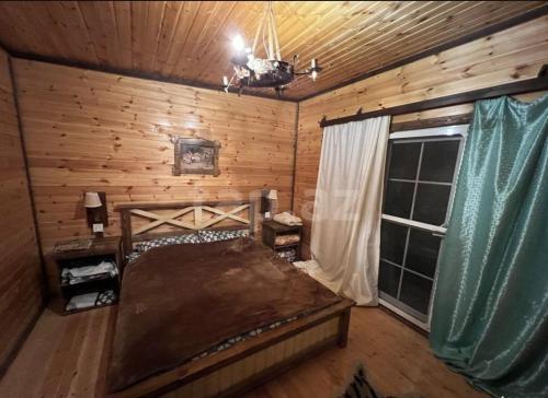 1 dormitorio con 1 cama en una cabaña de madera en A frame for families en Quba