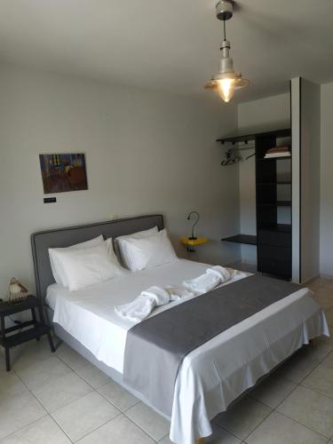a bedroom with a large bed with white sheets at Kykeon Studios in Katelios