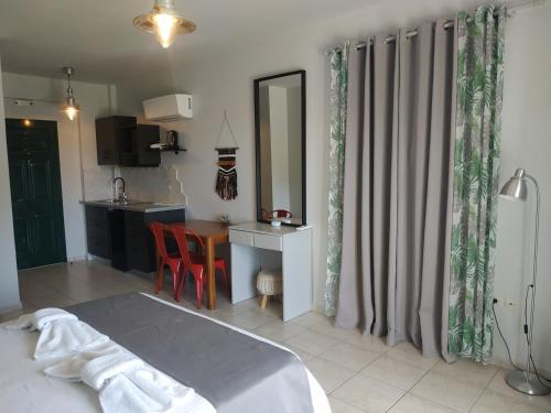 a bedroom with a bed and a table and a kitchen at Kykeon Studios in Katelios